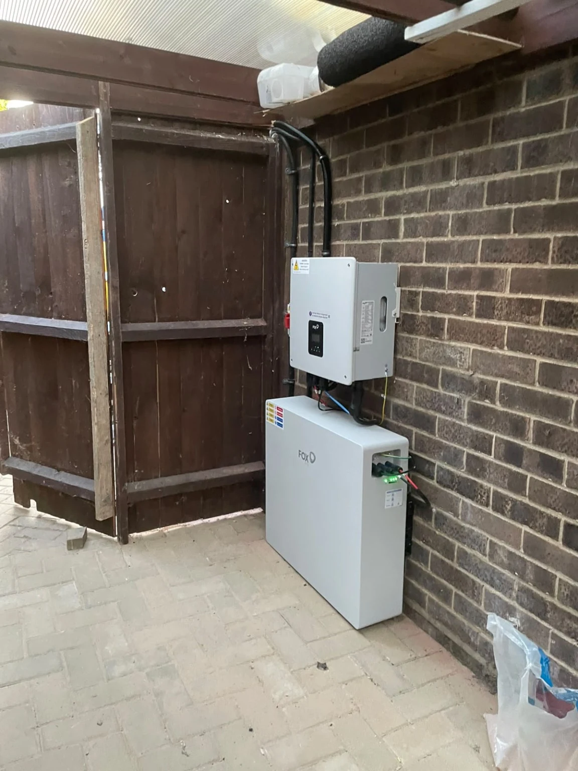 Fox inverter and battery installed against a brick wall